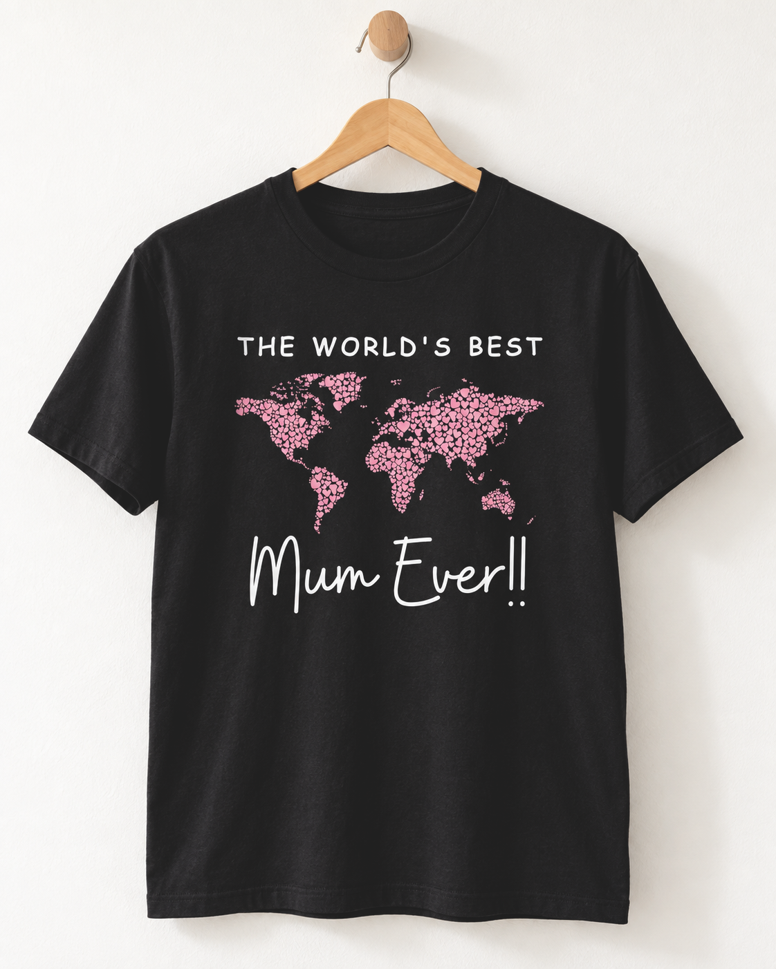 Adult black crewneck T-shirt hanging against a light wall, featuring a pink heart world map and “The World’s Best Mum Ever!!” slogan.