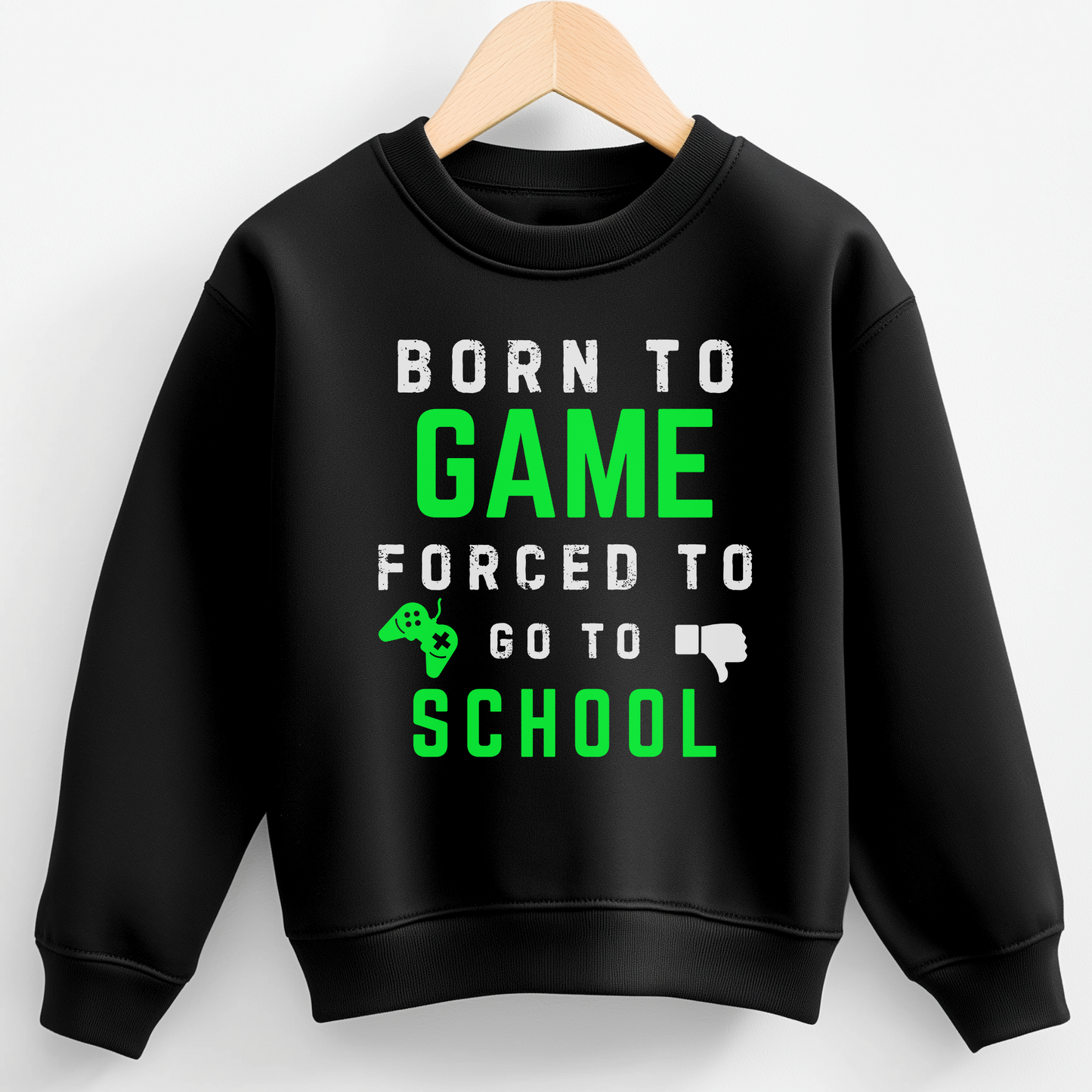 Kids black sweatshirt with bold green and white gaming slogan "Born to Game, Forced to Go to School" styled on a wooden hanger