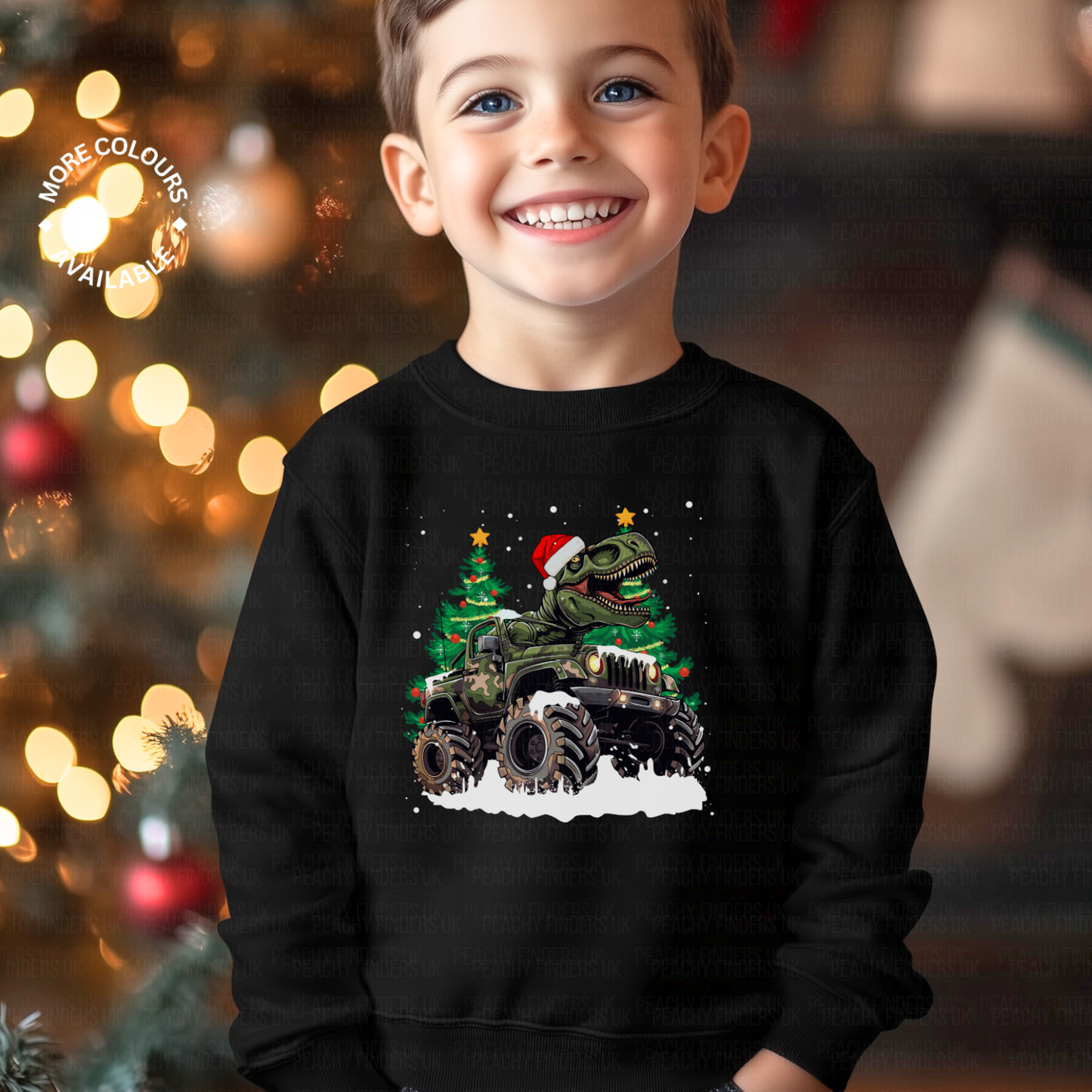 Smiling boy wearing a black Christmas sweatshirt with a T-Rex in a Santa hat driving a monster truck through snow, with decorated Christmas trees in the background.
