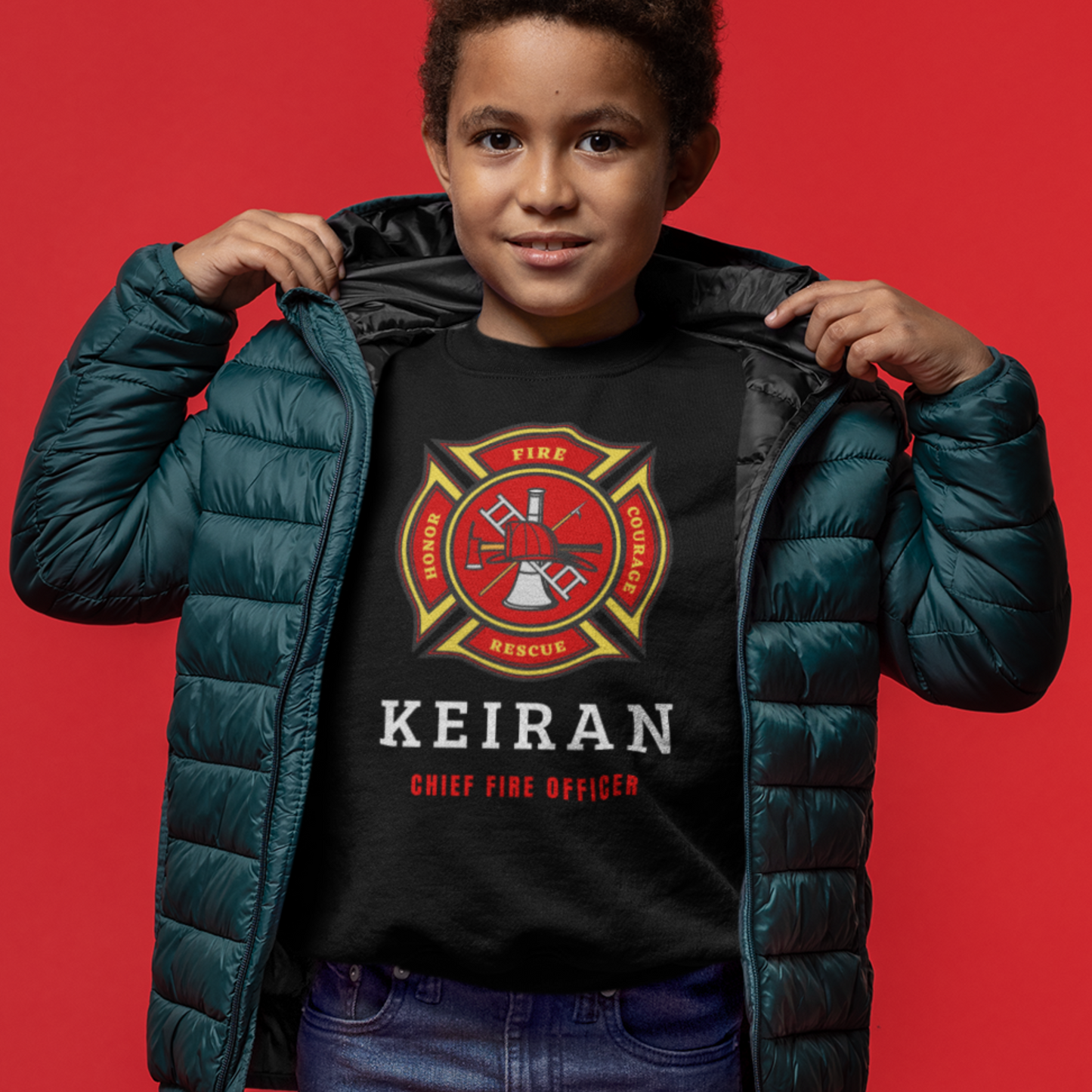 Young boy wears black sweatshirt with large red and yellow firefighter emblem and personalised name "Chief Fire Officer" printed on the front.