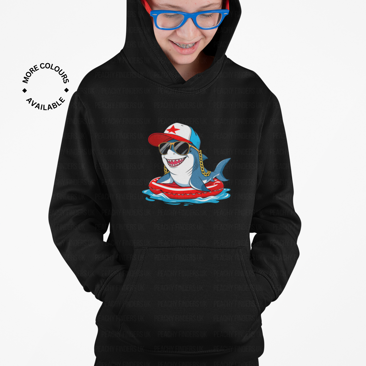 Young boy wearing a black hoodie with a fun cartoon shark design on a white background