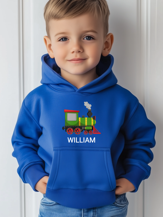 Young boy wearing a royal blue personalised steam train hoodie with his name printed underneath the locomotive illustration.