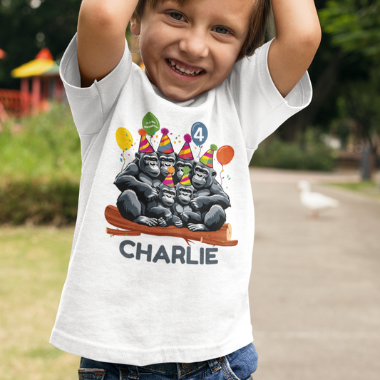 Boy wearing a personalised birthday t-shirt with a fun Gorilla family wearing party hats, sitting on a log with balloons and falling confetti - custom name and age added.