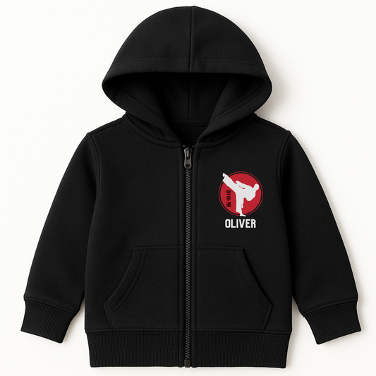 Kids black personalised karate zip hoodie with a red martial arts emblem and custom name printed on the left-side chest.