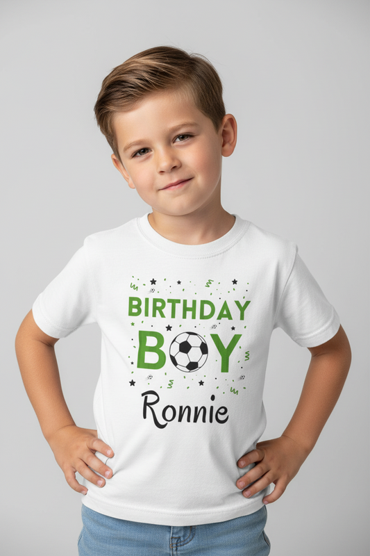 Boy modelling a white personalised “Birthday Boy” soccer t-shirt with the name Ronnie, hands on hips, light studio background