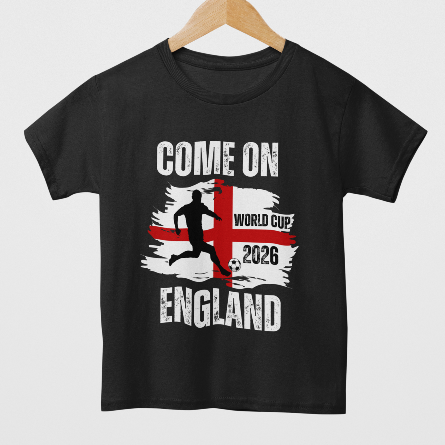 Kids black short-sleeved T-shirt with 'COME ON ENGLAND' and a graphic related to the World Cup 2026 styled on a wooden hanger.