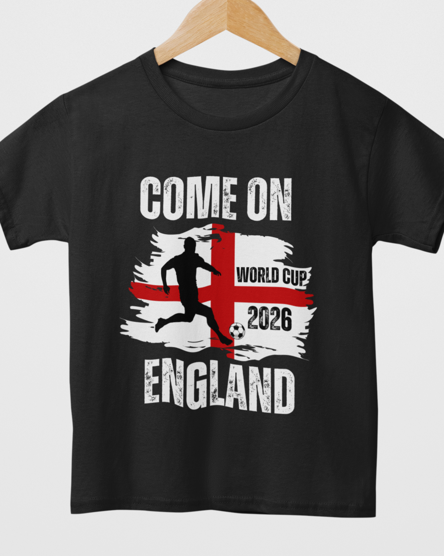 Kids black short-sleeved T-shirt with 'COME ON ENGLAND' and a graphic related to the World Cup 2026 styled on a wooden hanger.