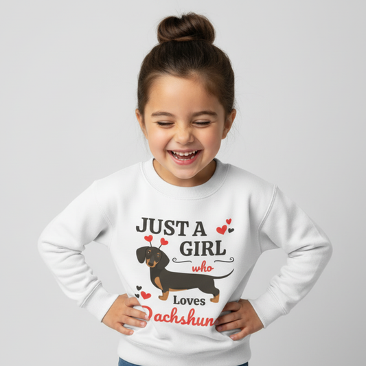 Happy young girl laughing while wearing a white “Just A Girl Who Loves Dachshunds” sweatshirt, hands on hips in a studio photo.