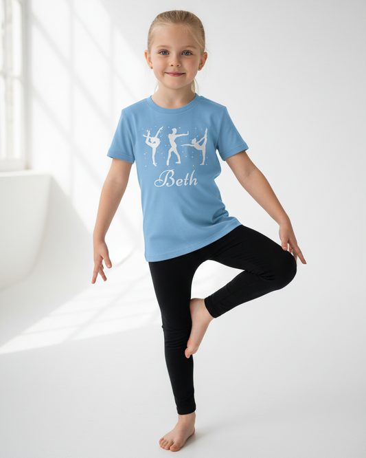Child posing in light blue custom name gymnastics t-shirt with black leggings in studio.
