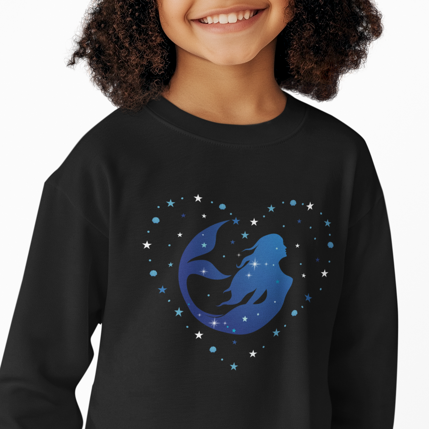 Close-up of a child wearing a black sweatshirt featuring a blue mermaid silhouette inside a heart made of stars.