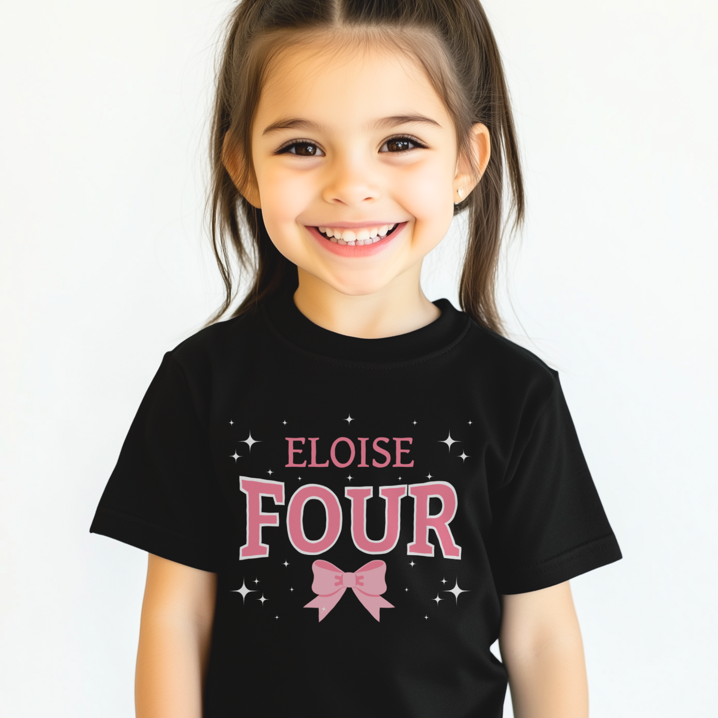 Little girl wearing kids black t-shirt featuring a printed graphic of large text 'Four' pink and white and pink bow and stars with personalised name.