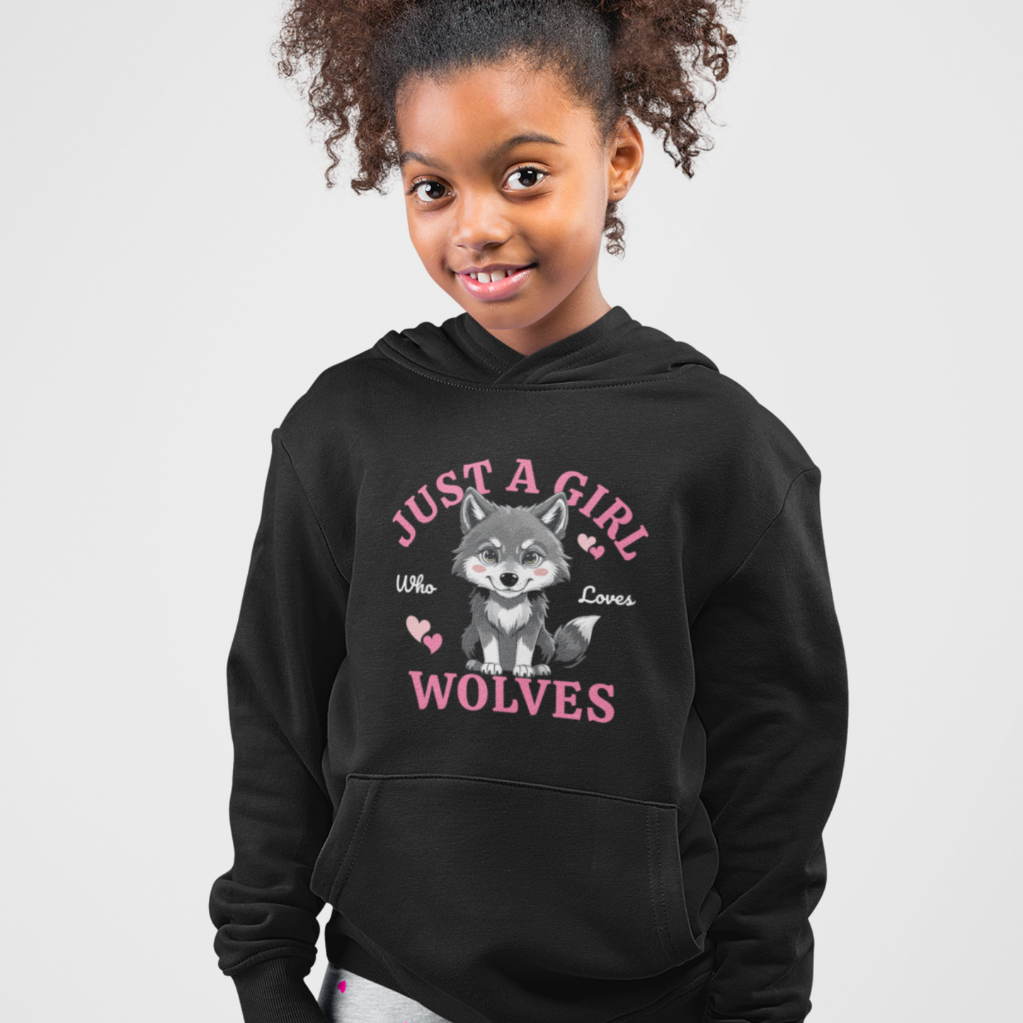 A young girl modelling a black pullover hoodie featuring "Just a girl who loves wolves" slogan and wolf cub graphic