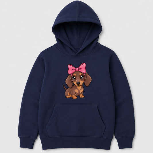 A kids navy blue pullover hoodie featuring a cartoon graphic of a brown dachshund wearing a pink bow on the chest, displayed against a light grey background.