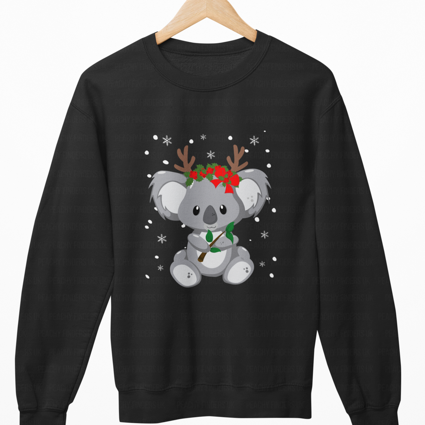 Black sweatshirt with a koala wearing reindeer antlers and a wreath on a wooden hanger