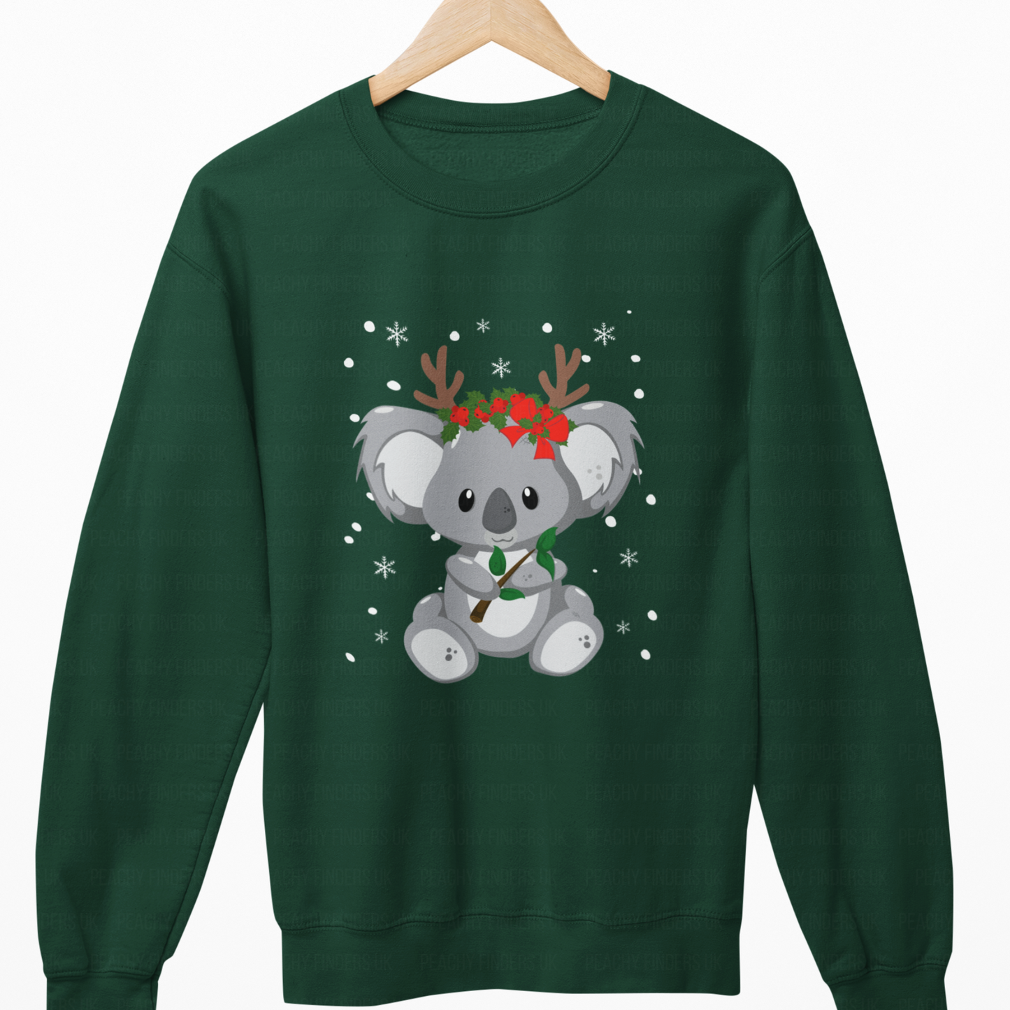 Green sweatshirt with a koala wearing reindeer antlers and a bow on a wooden hanger