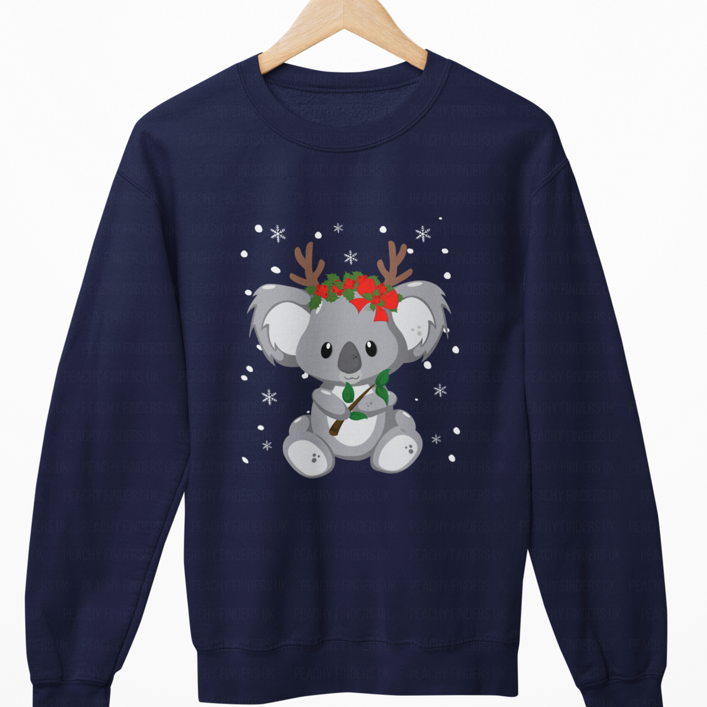 Navy blue sweatshirt with a koala wearing reindeer antlers and a wreath on a wooden hanger