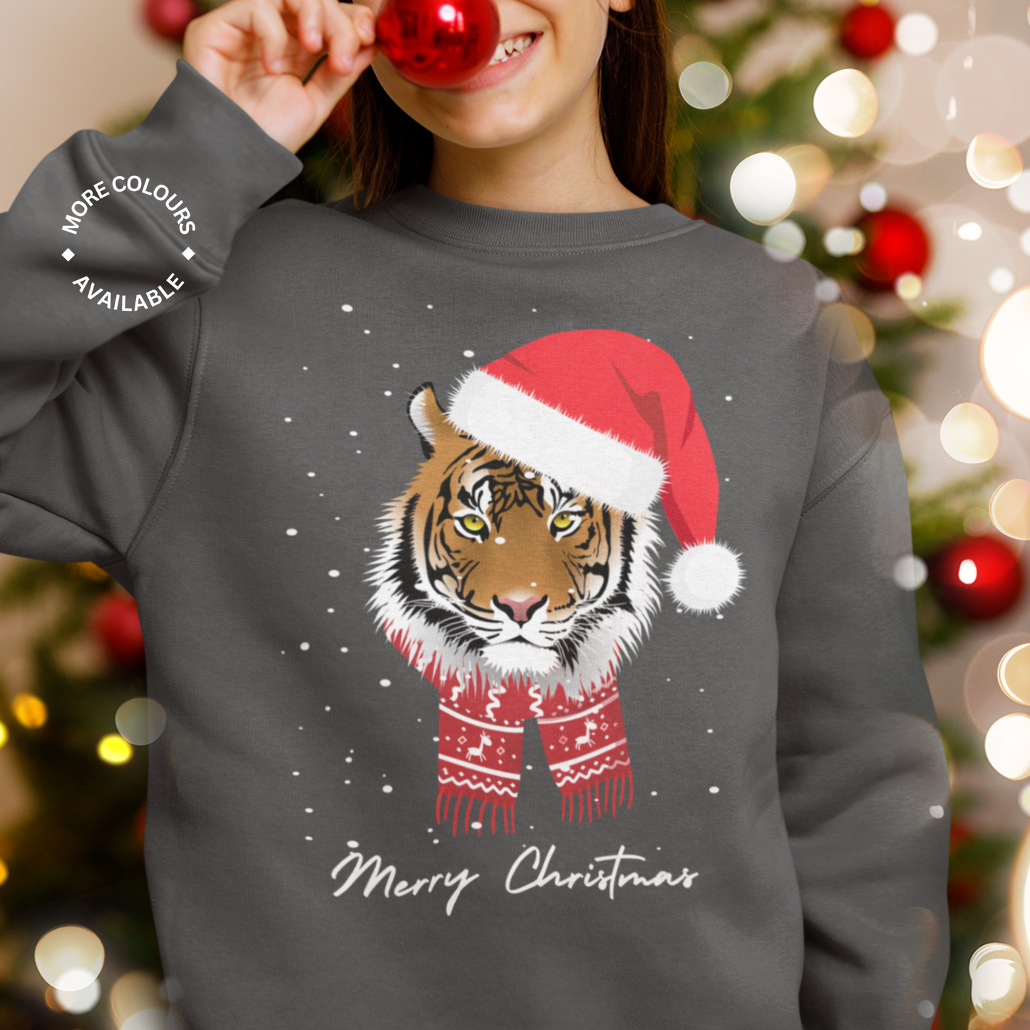 Girl wearing a charcoal grey Christmas sweatshirt featuring a festive tiger in a Santa hat and scarf with snow and “Merry Christmas” text