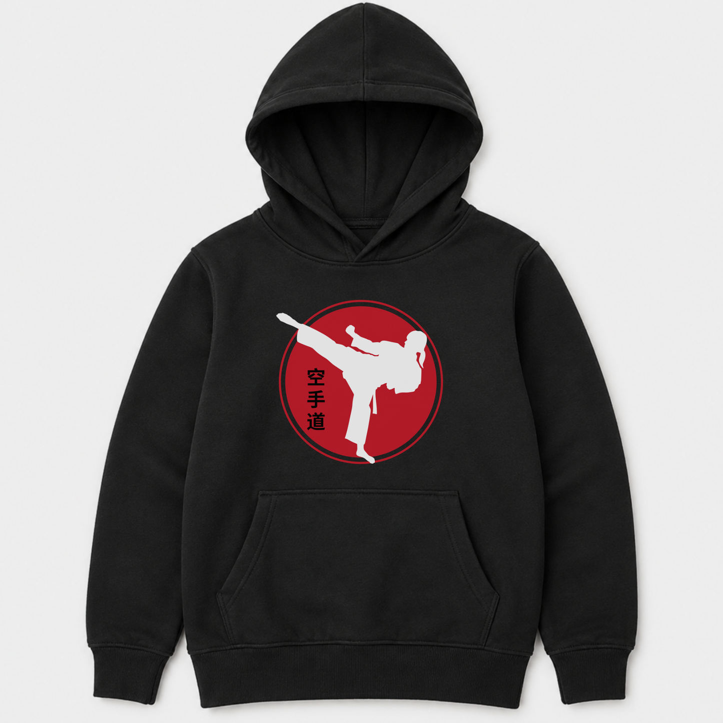 A girls black pullover hoodie with a front kangaroo pocket and a red circular graphic on the chest featuring a female white martial arts kick silhouette and vertical black characters, shown on a light grey background.