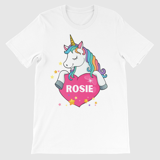 Girls personalised unicorn t-shirt featuring a rainbow-maned unicorn holding a pink heart with the name “Rosie” printed inside, surrounded by yellow and pink stars.