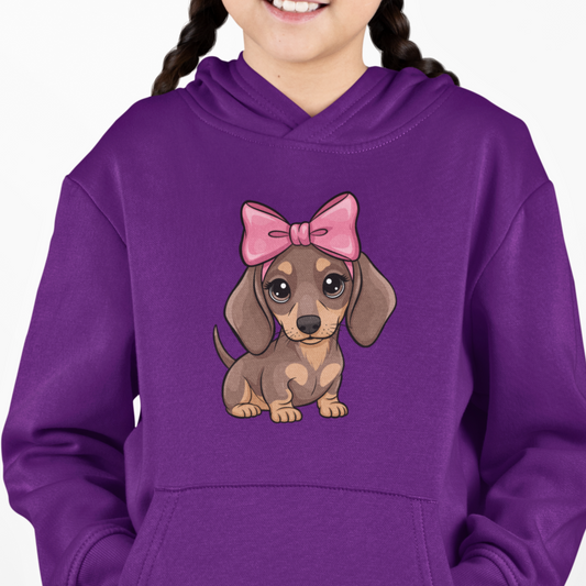 Young girl wearing a purple hoodie with a cartoon dachshund wearing a pink bow graphic.