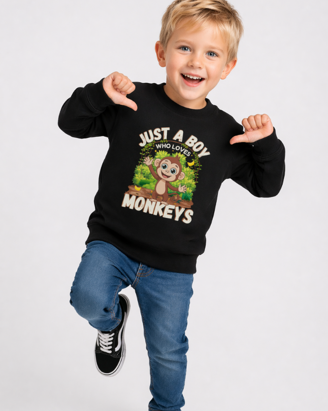 Young boy wearing black monkey sweatshirt smiling in playful pose, showcasing front graphic design
