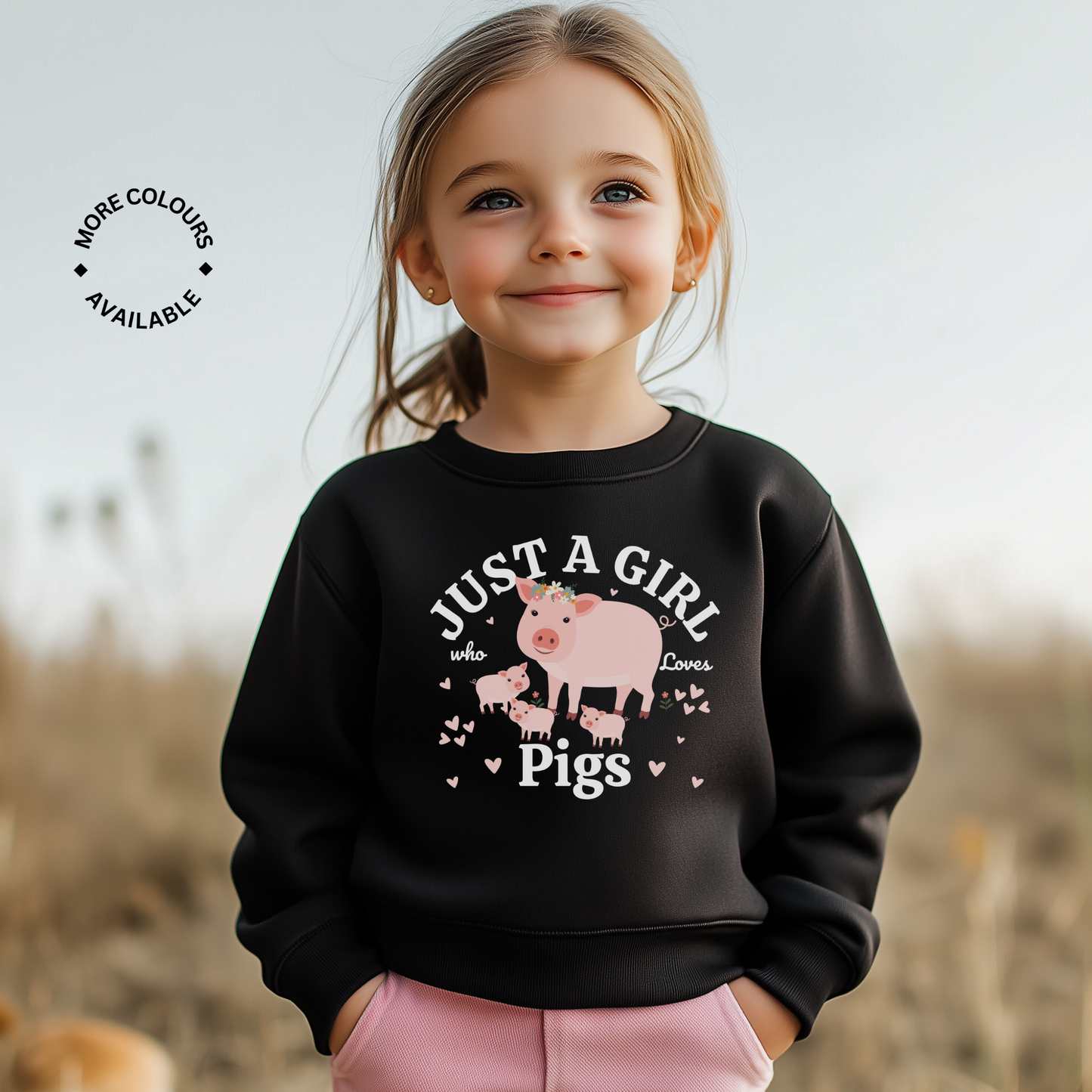 Little girl models a black sweatshirt featuring a cute farm-themed design with a pig and piglets surrounded by hearts and the text “Just a Girl Who Loves Pigs” printed across the front.