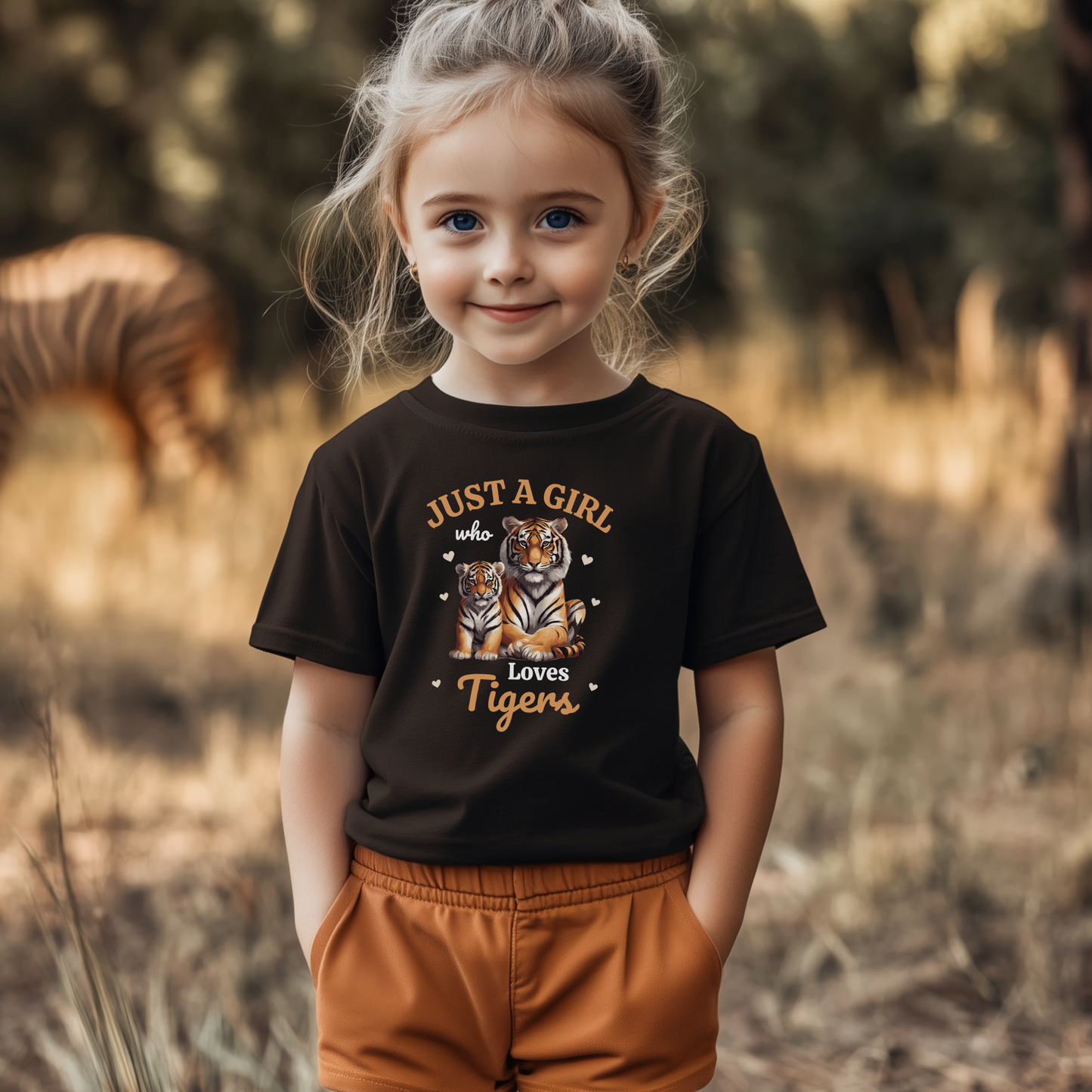Smiling young girl wearing a black T-shirt with “Just a Girl Who Loves Tigers” design featuring a mum and baby tiger surrounded by hearts