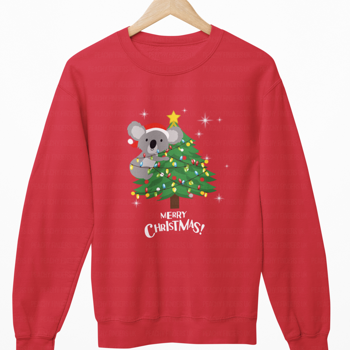 Red sweatshirt with a Christmas design of a koala on a tree, hanging on a wooden hanger.