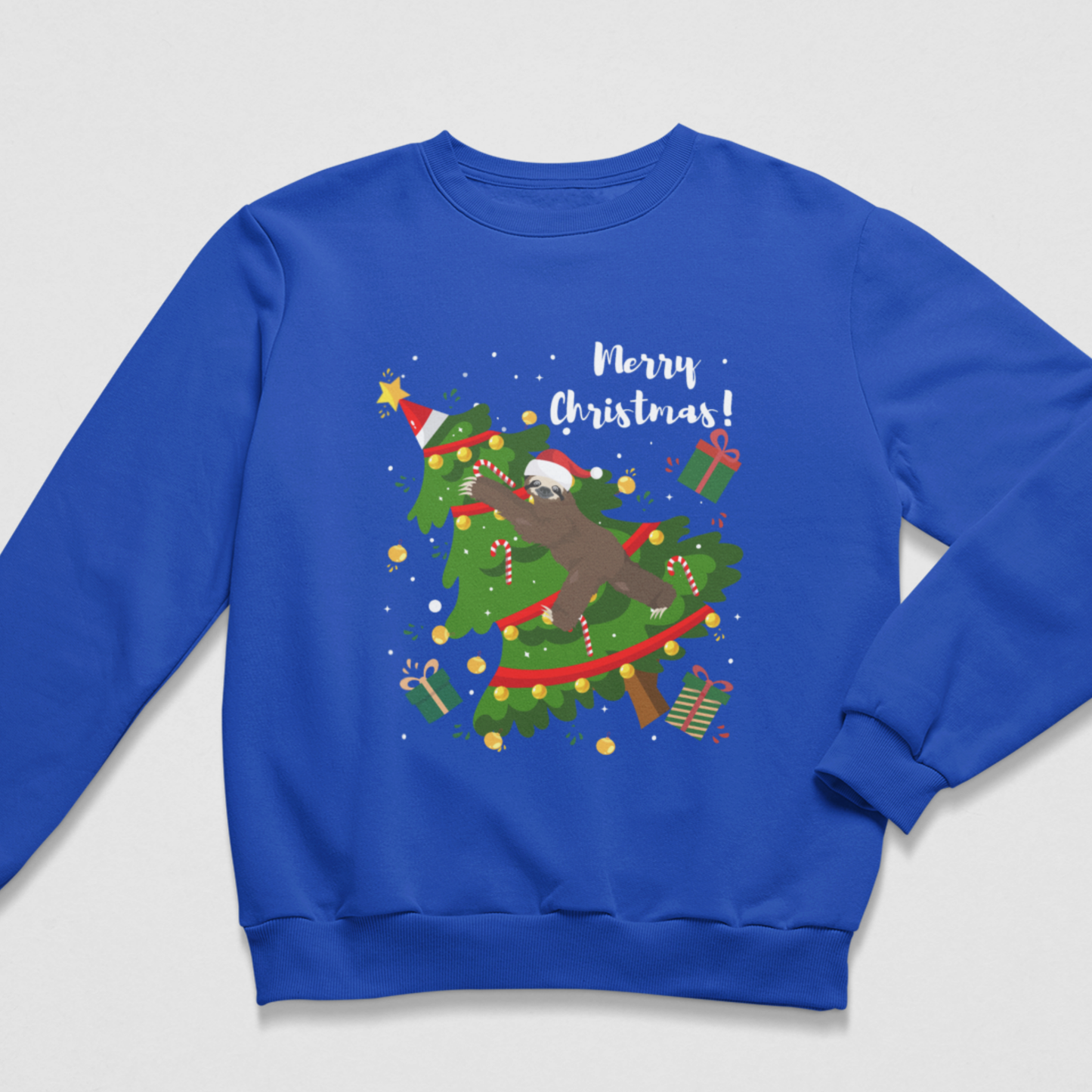 Royal blue kids Christmas jumper featuring a sloth in a Santa hat climbing through a decorated Christmas tree with presents, candy canes and Merry Christmas text