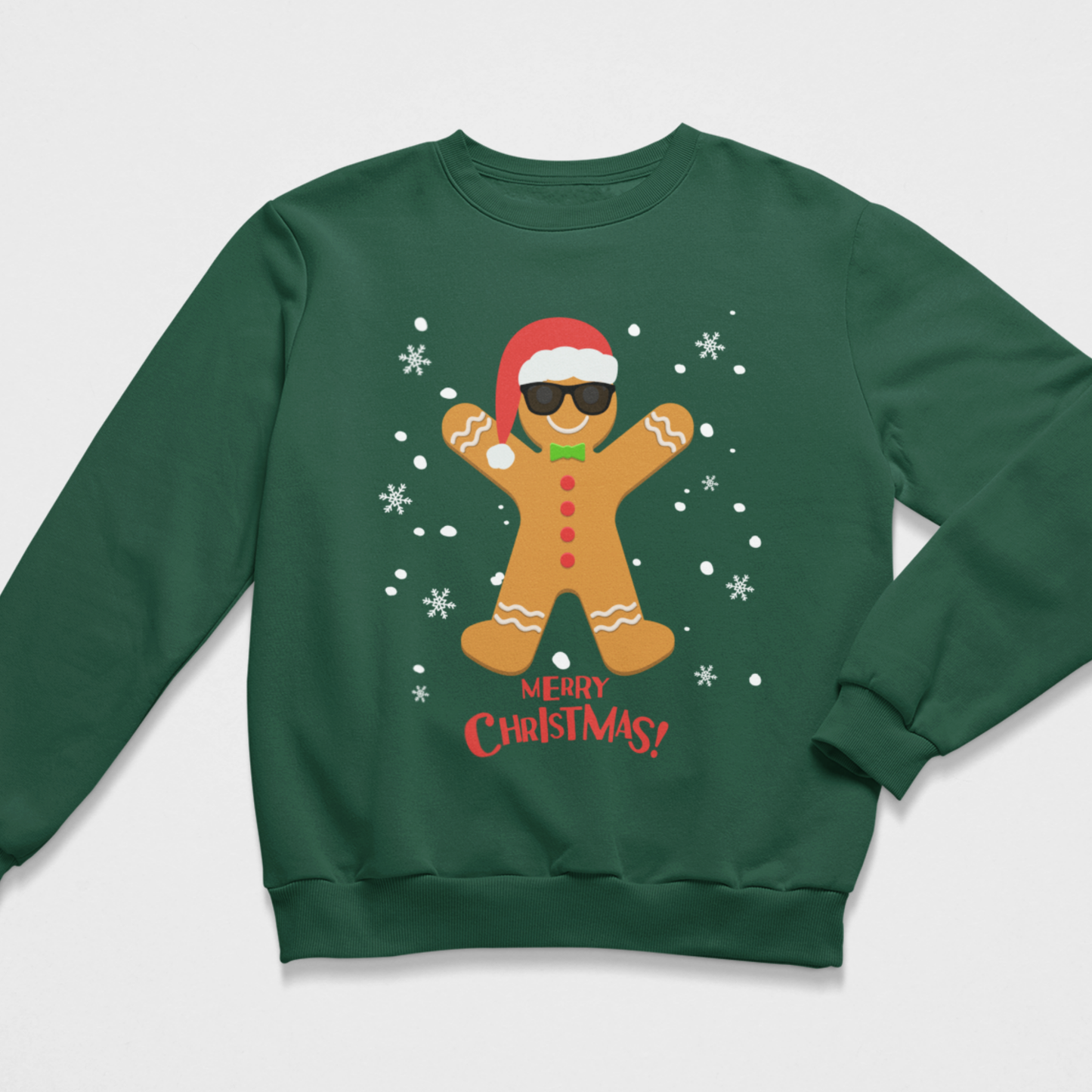 Dark green kids Christmas jumper featuring a gingerbread man wearing sunglasses and a Santa hat with falling snow and Merry Christmas text.