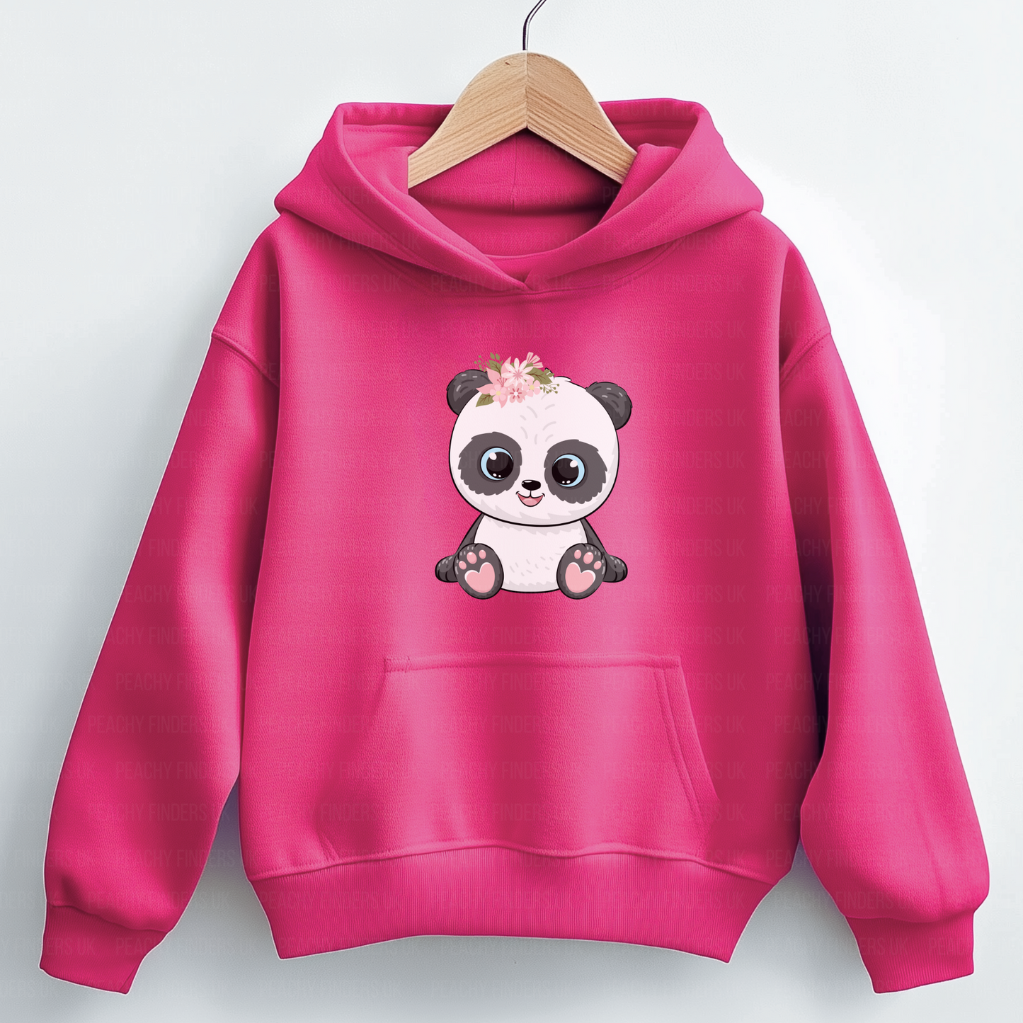 A vibrant hot pink hooded sweatshirt hangs on a light wooden hanger. The hoodie features a cute cartoon panda with large black and white eyes, sitting upright and wearing pink and white flowers on its head.