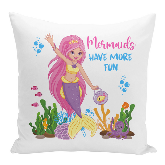 A white square cushion cover featuring a cartoon mermaid with long pink hair, a yellow top, and a purple and yellow tail. The text "Mermaids Have More Fun" is displayed above her. The mermaid is surrounded by colourful sea life, including fish, coral, bubbles and an octopus.
