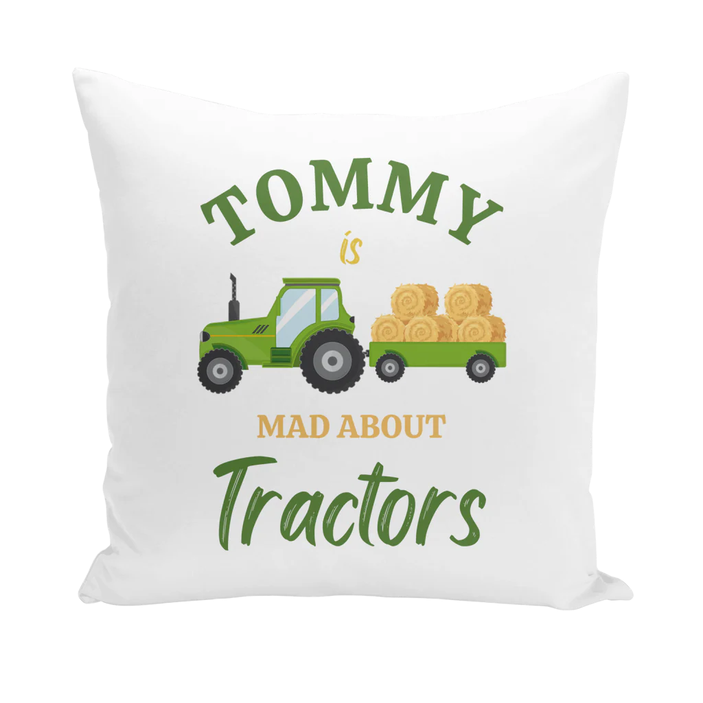 White personalised cushion cover with Tommy above a green tractor and hay-filled trailer, finished with green and gold “Mad About Tractors” lettering.