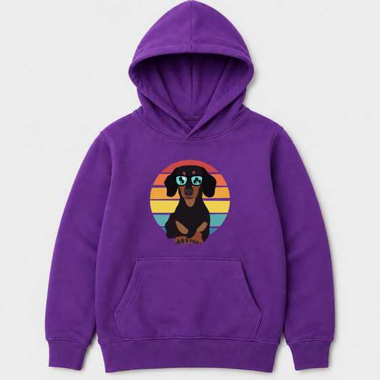 A purple kids pullover hoodie featuring a graphic of a dachshund wearing sunglasses against a retro sunset background, displayed on a light grey background.