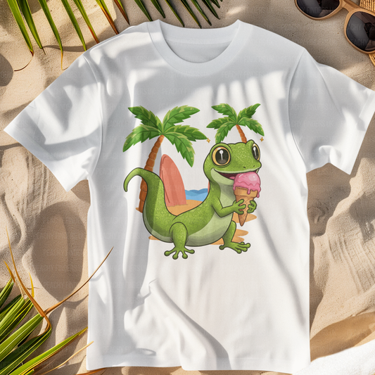 Kids white T-shirt on a sandy beach with a green gecko holding ice-cream, beach with palm trees in the background.