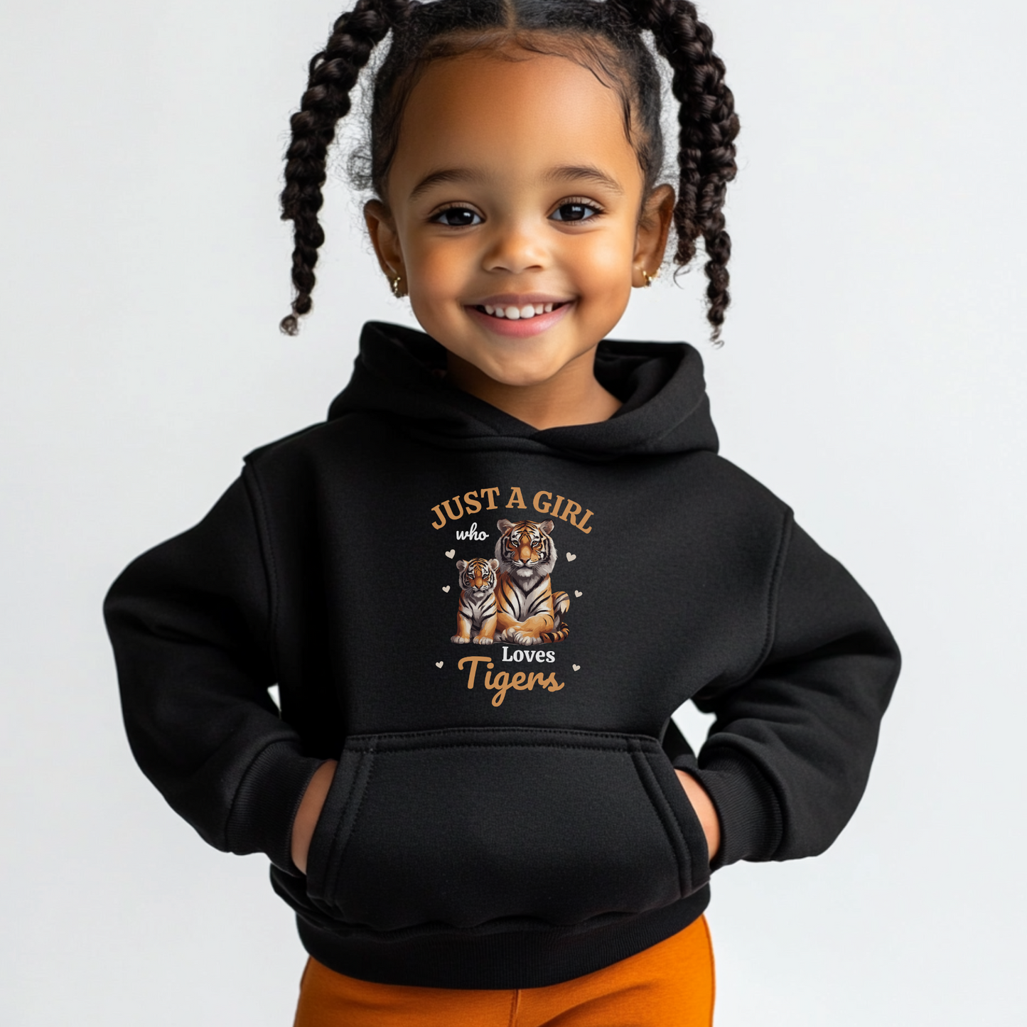 Smiling young girl wearing a black hoodie with “Just a Girl Who Loves Tigers” design featuring a mum and baby tiger surrounded by hearts.