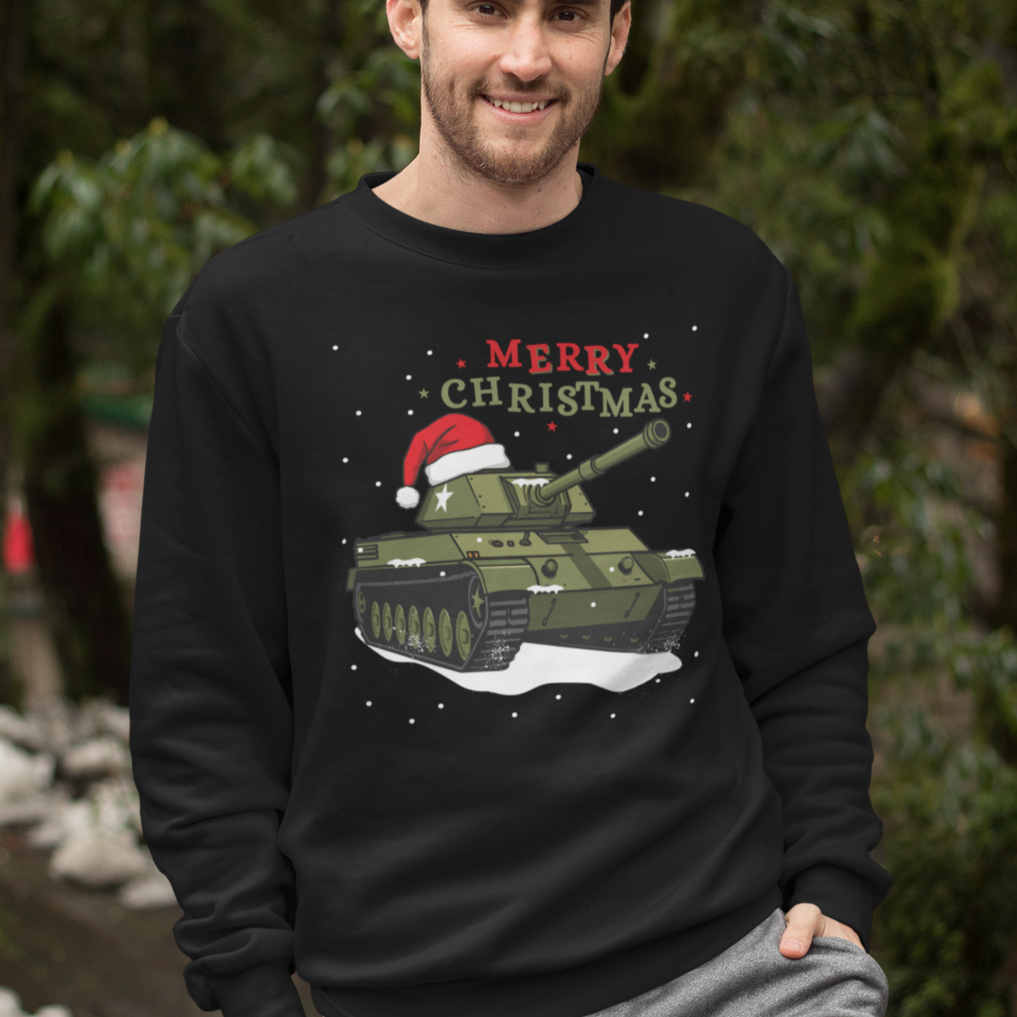 Adult wearing a black Christmas jumper featuring a military tank with a Santa hat and “Merry Christmas” text.