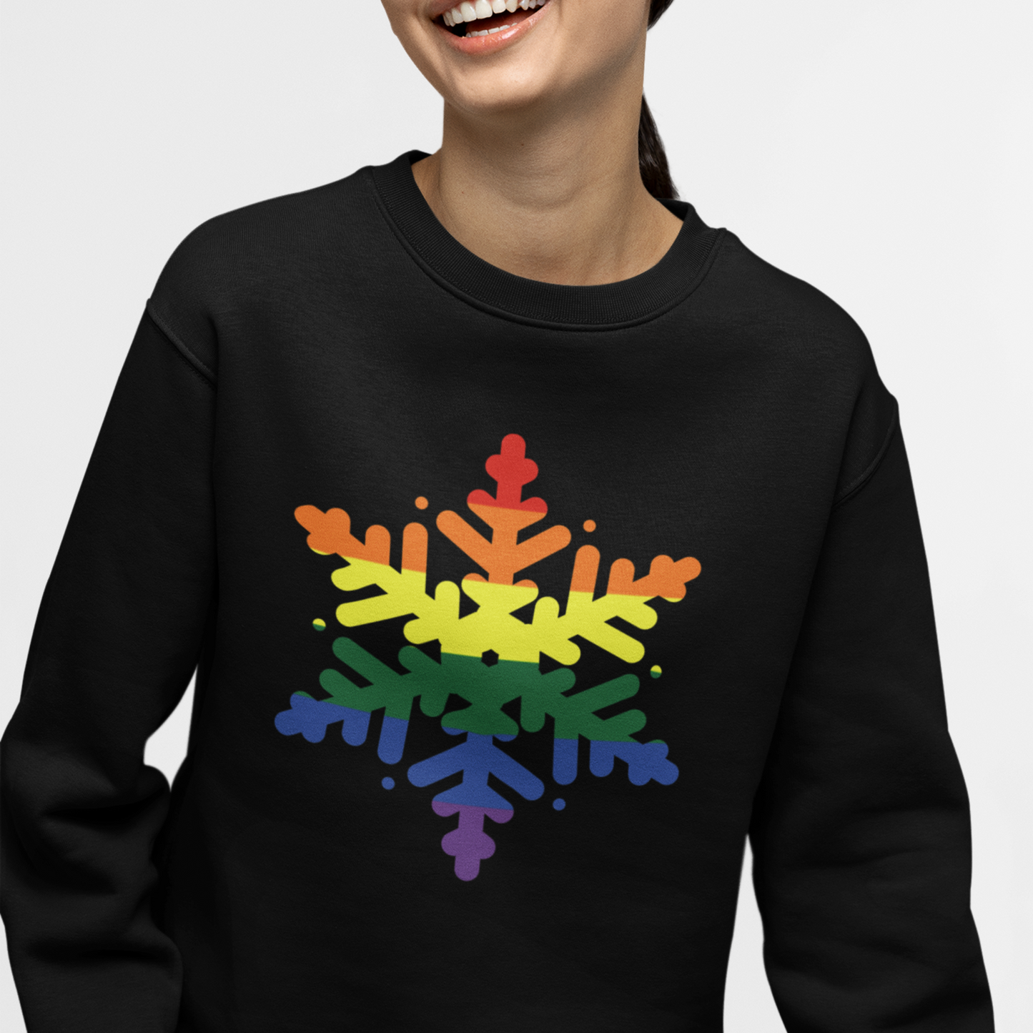 A person modelling a black sweatshirt featuring a large LGBT rainbow snowflake design printed on the front.