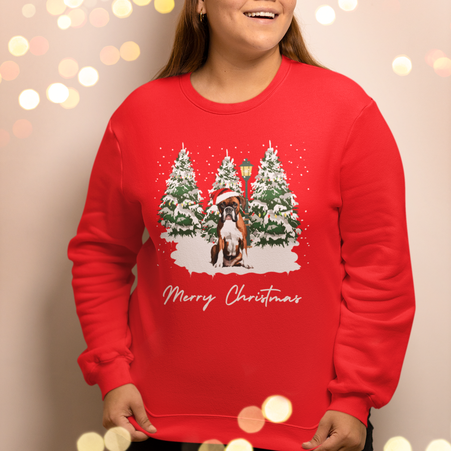 Red Christmas-themed sweatshirt with a boxer dog, trees, lamp-post and snow design, worn by a woman.
