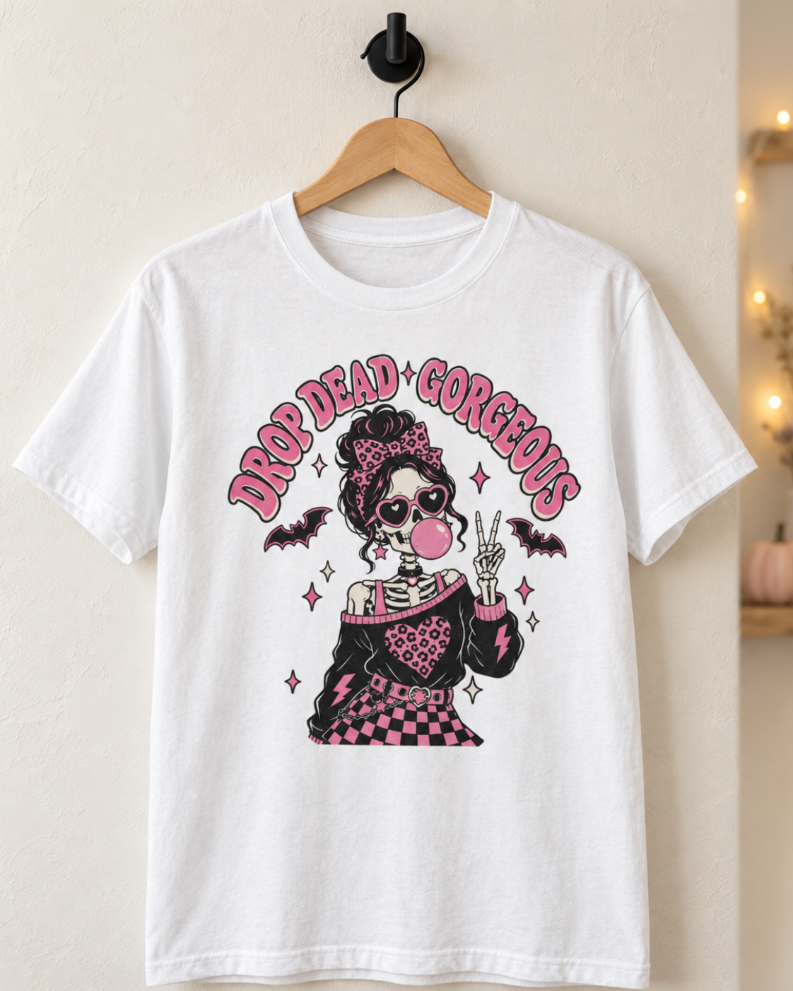 White Drop Dead Gorgeous skeleton Halloween T-shirt displayed on a wooden hanger