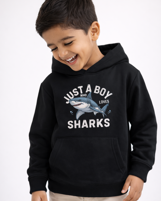 Happy little boy wearing black shark hoodie laughing, kids “Just A Boy Who Loves Sharks” sweatshirt close up