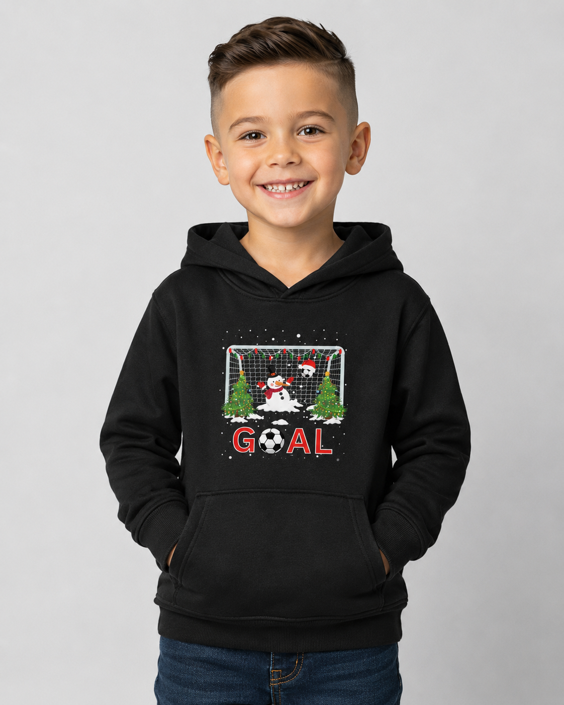 Boy wearing a black kids Christmas football hoodie with festive snowman goalkeeper, goal net, Christmas trees and bold GOAL design.