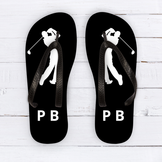 Men's golf flip flops with personalised name on white wood flooring