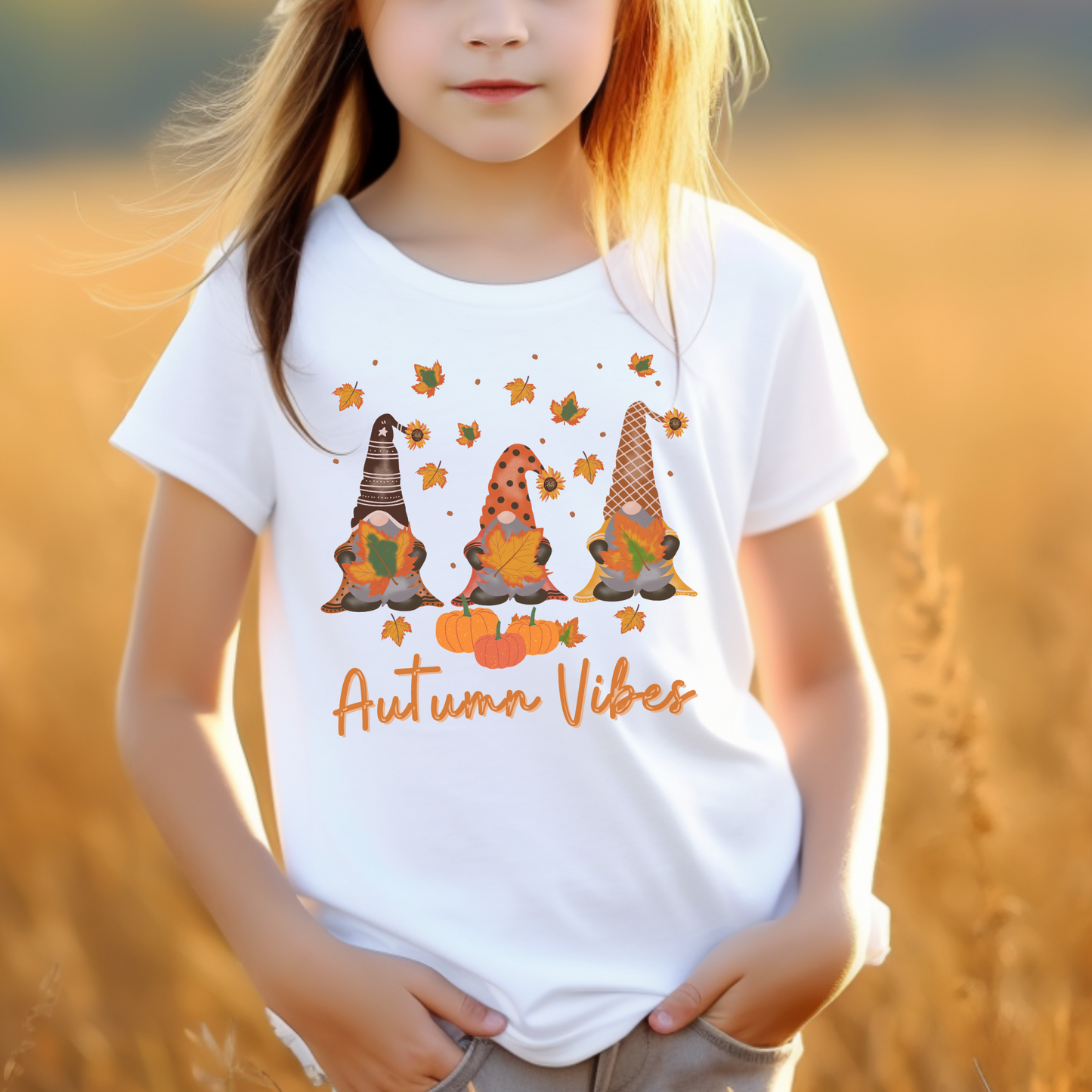 Little girl wearing a white t-shirt with printed autumn gonks and the words "autumn vibes"