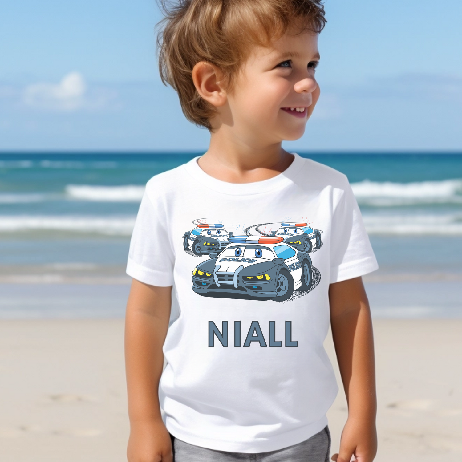 A little boy wearing a white short sleeve t-shirt printed police chase and personalised name