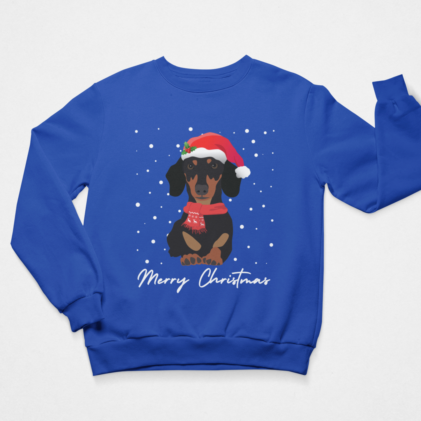A royal blue crewneck sweatshirt featuring a graphic of a dachshund wearing a red Santa hat and scarf against a snowy background, with 'Merry Christmas' written in white script below.