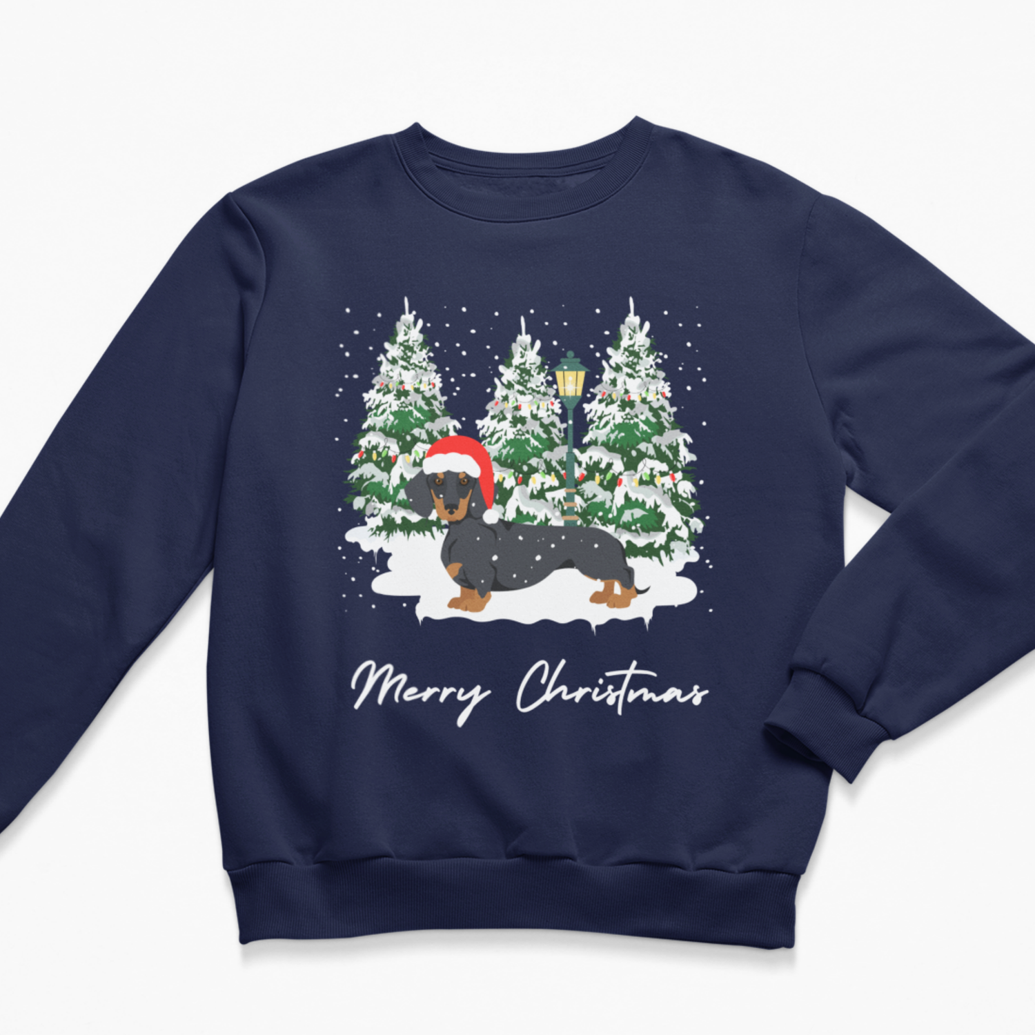 A navy blue crewneck sweatshirt featuring a festive Christmas graphic of a black and tan dachshund wearing a red Santa hat, standing in a snowy winter forest with the text 'Merry Christmas' written below in white script.