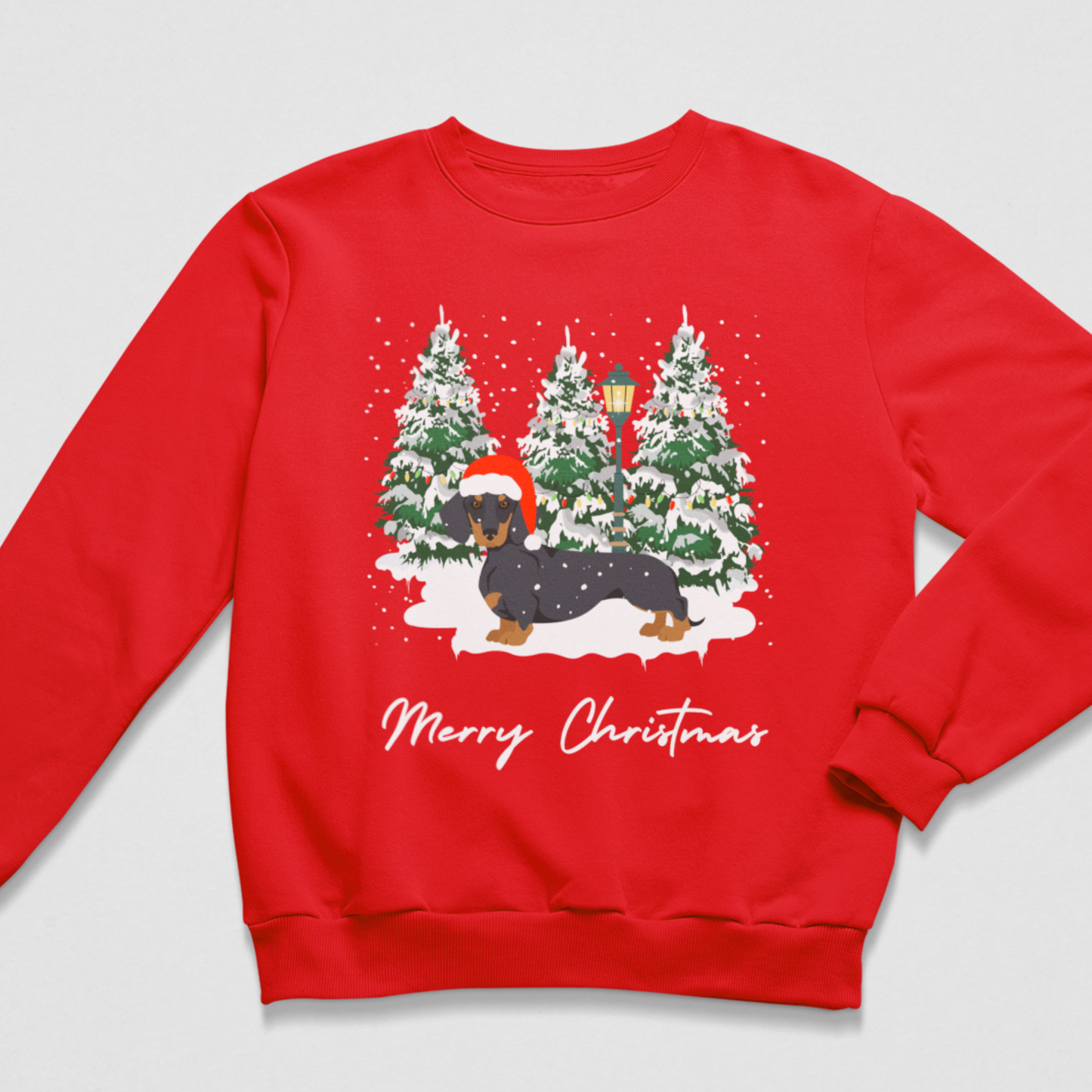 A red crewneck sweatshirt featuring a festive Christmas graphic of a dachshund in a snowy winter scene with pine trees and the text 'Merry Christmas' printed below.