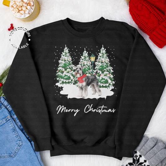 Adults black Christmas sweatshirt with a Schnauzer wearing a festive red scarf, snow scene and Christmas trees design.