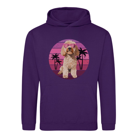 A purple unisex adult hoodie with a graphic of a cockapoo dog wearing sunglasses, surrounded by a pink circle and palm trees in the background.